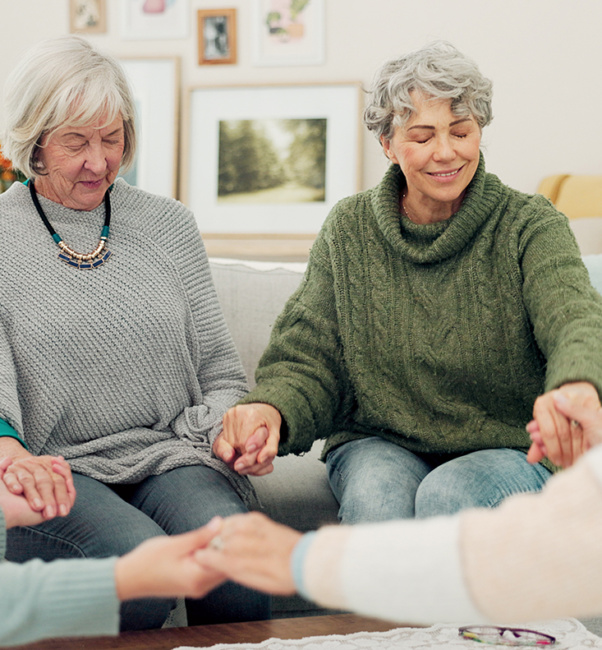 women sitting around in a prayer circle
