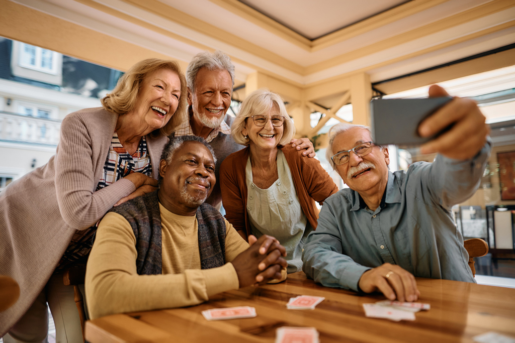 A group of older adults smiling and taking a selfie.