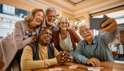 A group of older adults smiling and taking a selfie.