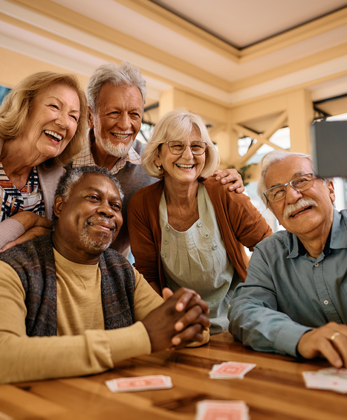 A group of older adults smiling and taking a selfie.